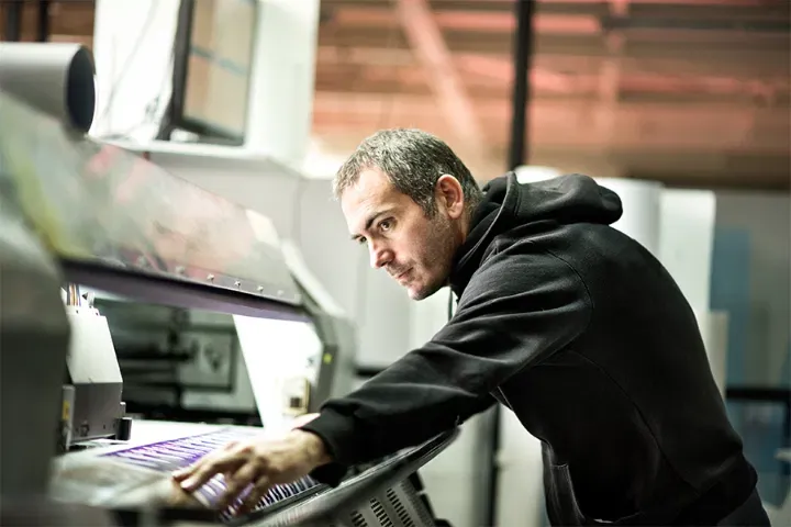 Production technician checking a large-format print run